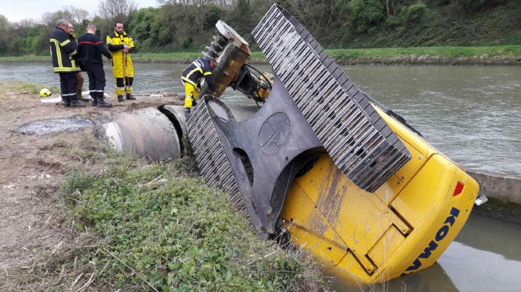 Les hommes de l’Unité de risques technologiques vont éviter que le gazole contenu dans le réservoir de la grue ne se déverse dans le canal de Neuffossé et n’entraîne une pollution. (Photo LA VOIX DU NORD)